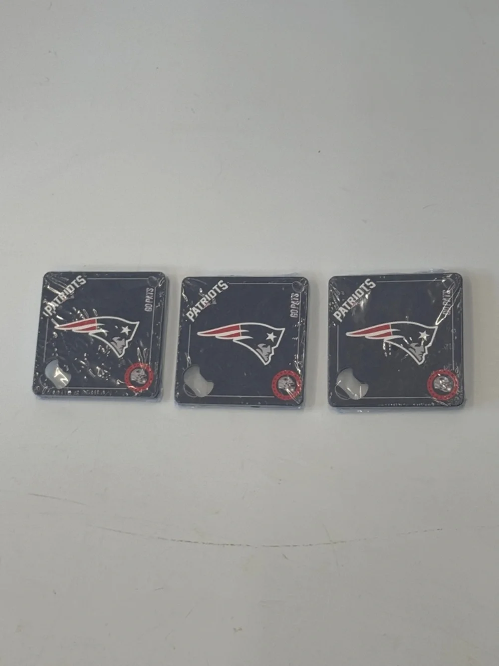 Set of 12 Metal “Patriots” Coasters with bottle opener.